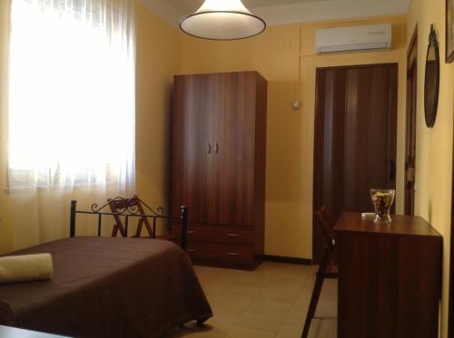 a bedroom with a bed and a cabinet and a table at Il Cavaliere in Trapani