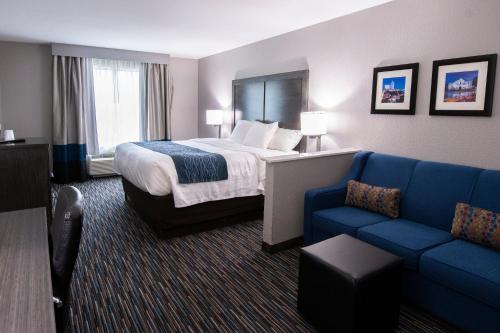 a hotel room with a bed and a blue couch at Comfort Inn & Suites Near Medical Center in San Antonio