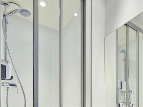 a bathroom with a shower with glass doors at hotelF1 Lille Englos in Haubourdin