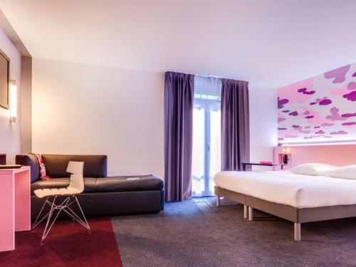 a hotel room with a bed and a couch at ibis Styles Nantes Centre Gare in Nantes