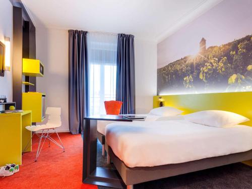 a hotel room with a large bed and a desk at ibis Styles Nantes Centre Gare in Nantes