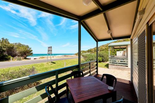 a table on a balcony with a view of the ocean at Kennett River Family Caravan Park in Wye River