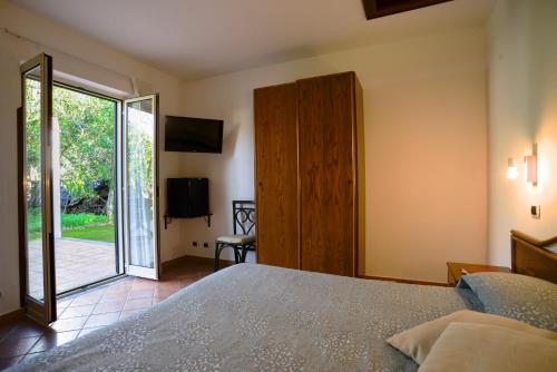 Schlafzimmer mit einem Bett und einer Glasschiebetür in der Unterkunft Agriturismo Piccolo Canyon in Piano di Sorrento