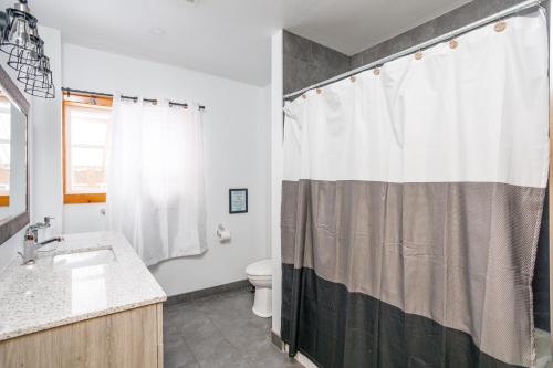 een badkamer met een douchegordijn en een toilet bij Blue Mtn Chalet with Hot Tub and Sauna, Sleeps 20 in Blue Mountains