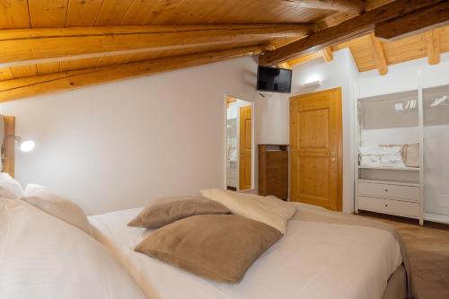 a bedroom with a white bed with two pillows at Residenza Marconi in Pinzolo
