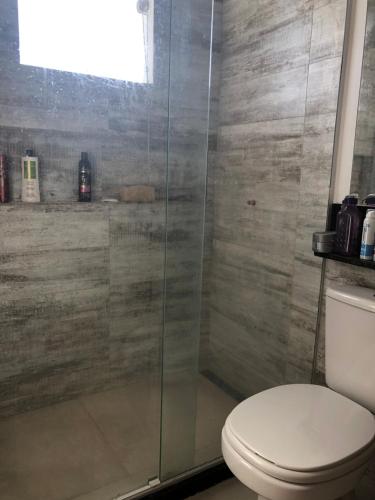 Un baño con inodoro y ducha de cristal. en Casa espaçosa cpm linda vista pro verde, en Búzios
