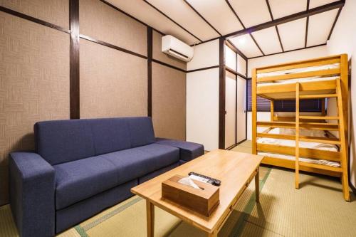 sala de estar con sofá azul y cama en 雅宿NF203, en Osaka
