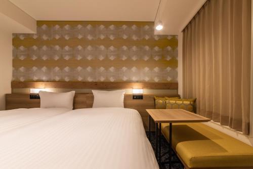 a hotel room with a bed and a table and chairs at Hotel Vista Osaka Namba in Osaka