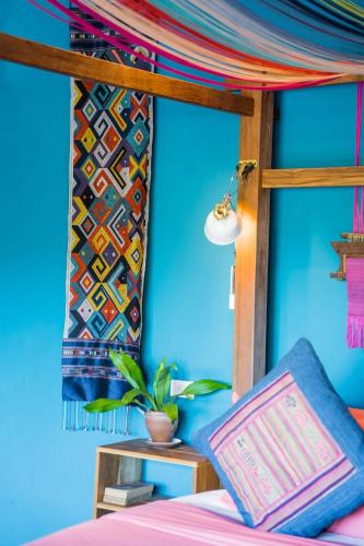 a bedroom with a bed and a blue wall at Ock Pop Tok Mekong Villa in Luang Prabang
