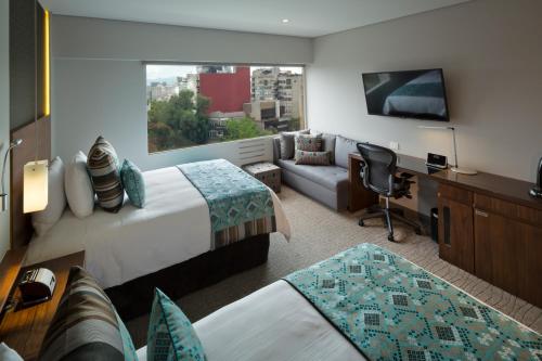 メキシコシティにあるInterContinental Presidente Mexico City, an IHG Hotelのベッド2台とデスクが備わるホテルルームです。