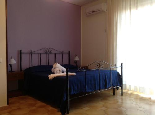 a bedroom with a black bed with blue sheets and a window at Il Cavaliere in Trapani