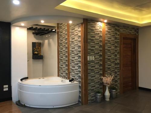 a bath tub in a room with a brick wall at Rangya Hotel in Tagaytay