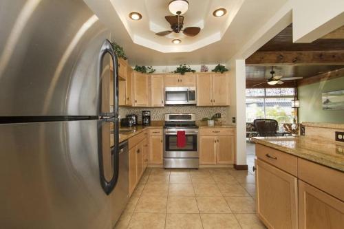 a kitchen with a stainless steel refrigerator and wooden cabinets at Hawaiian King in Honolulu