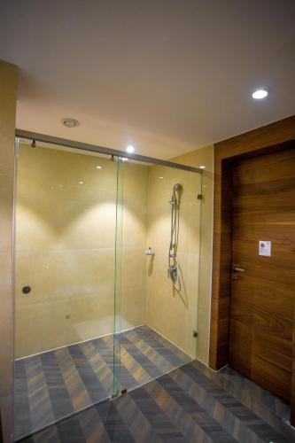 a shower with a glass door in a bathroom at Citadel Hotel By Vinnca in Hyderabad