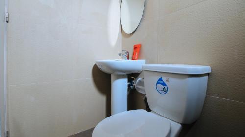 a bathroom with a white toilet and a sink at RedDoorz at Hotel Rosemarie in Manila