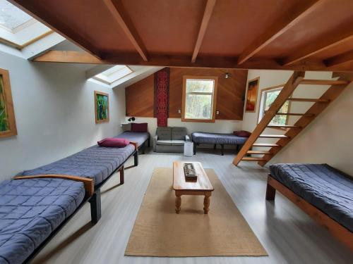 a room with three beds and a table in a room at Te Nikau Retreat in Punakaiki