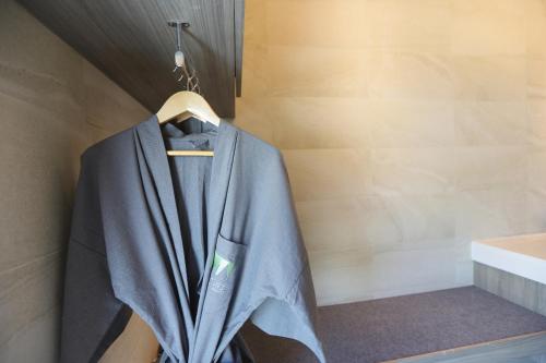 a suit hanging on a hanger in a bathroom at The Signature Hotel Airport in Hat Yai