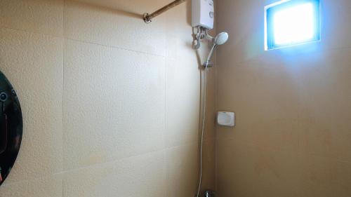 a shower in a bathroom with a window at RedDoorz at Hotel Rosemarie in Manila