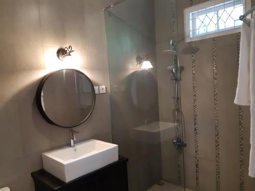a bathroom with a sink and a mirror and a shower at Hotel Purnama Lenggang in Gantung