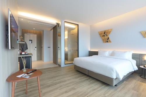 a hotel room with a bed and a table at The Signature Hotel Airport in Hat Yai