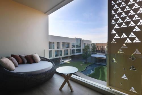 a room with a large window with a bed and a table at The Signature Hotel Airport in Hat Yai