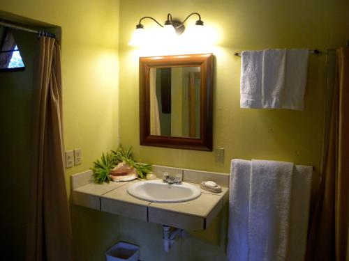 a bathroom with a sink and a mirror at Tranquility Bay Beach Retreat in Trujillo