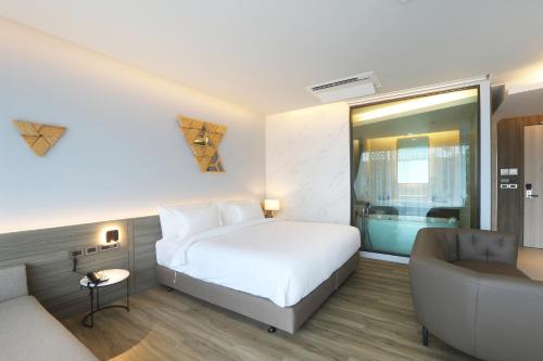 a hotel room with a bed and a couch at The Signature Hotel Airport in Hat Yai