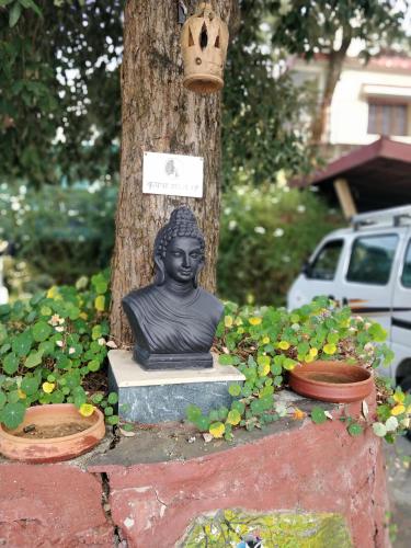 a statue of a bust sitting next to a tree at Hotel SunGrace in Mussoorie