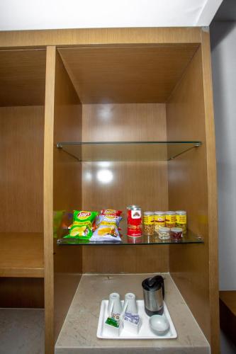 a cabinet with food and drinks on a shelf at Citadel Hotel By Vinnca in Hyderabad