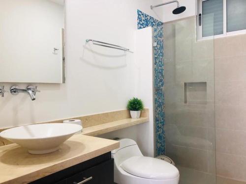 a bathroom with a toilet and a sink and a shower at Apartamentos Cartagena Oceano - Eliptic in Cartagena de Indias