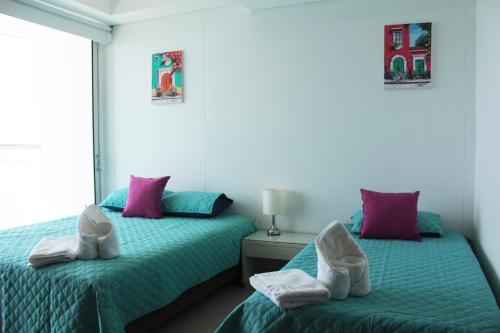 two beds sitting next to each other in a bedroom at Apartamentos Cartagena Oceano - Eliptic in Cartagena de Indias