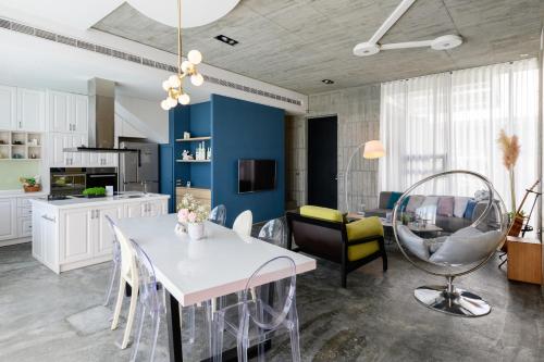 a kitchen and living room with a white table and chairs at Villa Le Ballon Bleu in Wujie