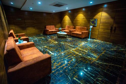 a room with couches and chairs on a floor at Citadel Hotel By Vinnca in Hyderabad