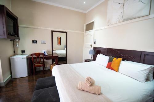 um quarto com uma cama com duas toalhas em New England Guest House by Ilawu em Pietermaritzburg