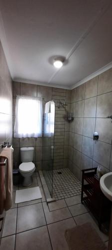 a bathroom with a shower and a toilet and a sink at La Dolce Vita No. 3 in St Lucia