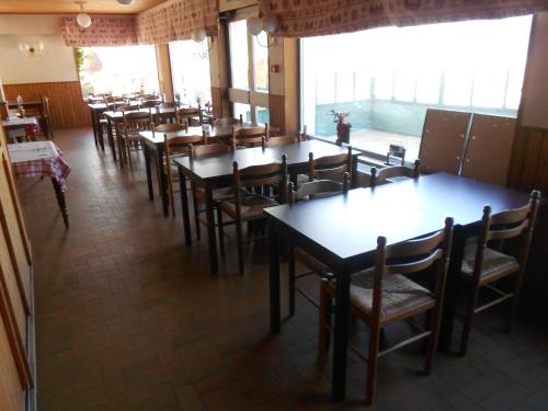 une rangée de tables et de chaises dans un restaurant dans l'établissement Hôtel L'Orée du Bois, à Xonrupt-Longemer