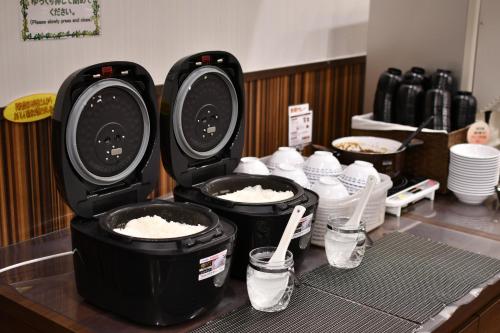 a counter with three pots of rice and bottles of water at Bell's Inn Tsuchiura in Tsuchiura