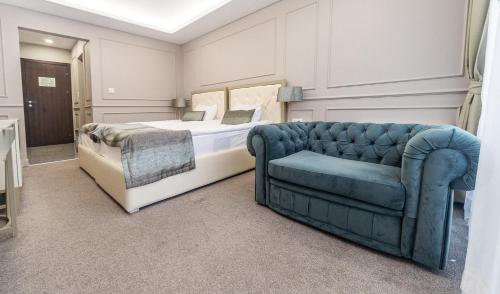 - une chambre avec un lit et un canapé bleu dans l'établissement Monte Vedetta, à Sliven