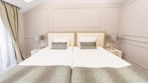 a bedroom with a white bed with two lamps at Monte Vedetta in Sliven