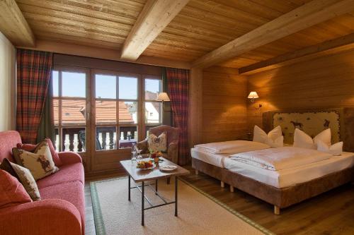 um quarto com uma cama, um sofá e uma mesa em Hotel Gasthof Alte Post Holzkirchen em Holzkirchen