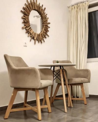 a table and two chairs and a mirror at Villa Thiranthemis in Fira