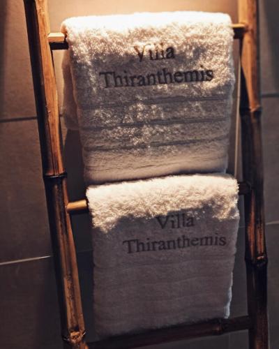 a stack of towels on a towel rack in a bathroom at Villa Thiranthemis in Fira