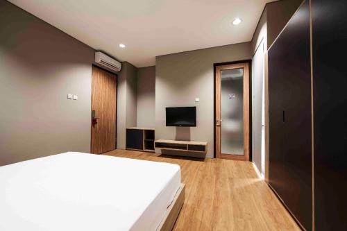 a bedroom with a bed and a flat screen tv at M Suite in Tangerang