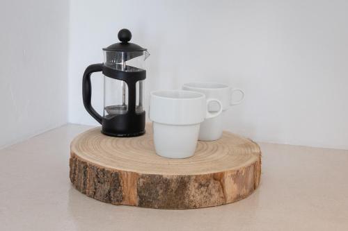 a coffee maker and coffee cups on a wooden table at Villa Thiranthemis in Fira