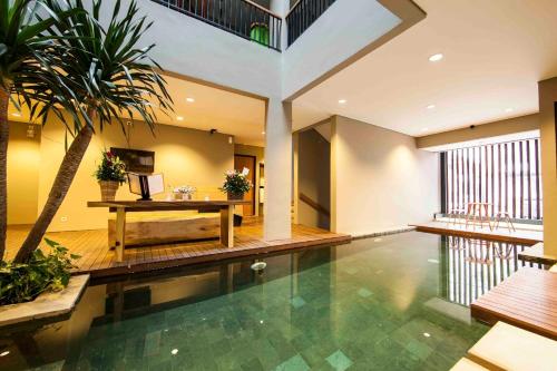an indoor pool with a table and a palm tree at M Suite in Tangerang