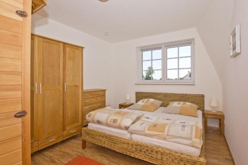ein Schlafzimmer mit großem Bett und Fenster in der Unterkunft Ostseehaus Lea Doppelhaushälfte in Wiek auf Rügen 