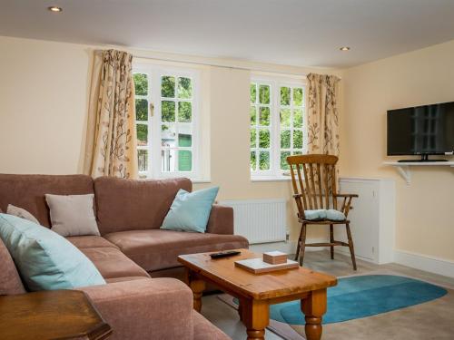 uma sala de estar com um sofá e uma mesa em Vicarage Cottage em Kenton