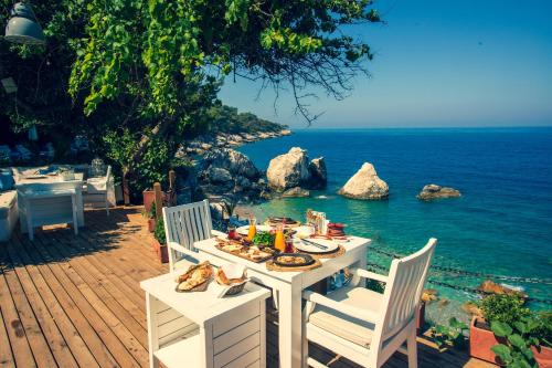 a table with food on it next to the ocean at Nautical Hotel in Faralya