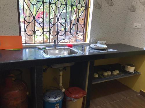 a kitchen counter with a sink and a window at John's Highland Comfort (Guest House) in Majorda