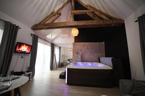 een grote kamer met een bad in het midden van een kamer bij Eaudyssée maison avec SPA privée - Loiret in Ladon